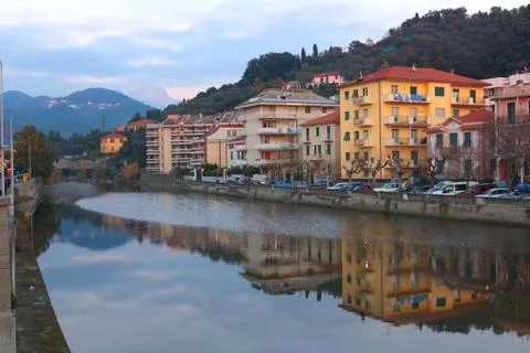 View of old town by mountain river at sunset. Plants and trees, mountains of Stock Photos