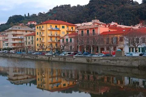 View of old town by mountain river at sunset. Plants and trees, mountains of Stock Photos