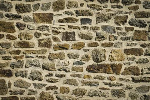 View of old wall built with stones in warm tones. Stock Photos