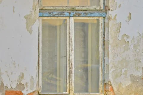 View of an old window and a scratched facade. Dusted facade with a window on an Fotos de archivo