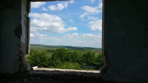 View from the old window of green meadows and blue sky with white clouds Stock Photos