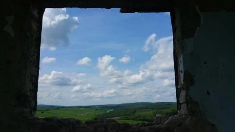 View from the old window of green meadows and blue sky with white clouds Stock Photos