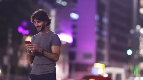 View of one young caucasian man with smartphone at night time Stock Footage 268810380