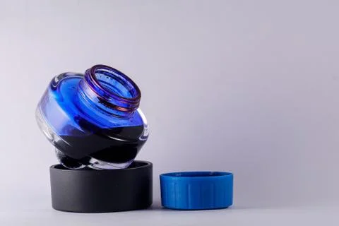 A view of open blue ink bottle against white background Stock Photos