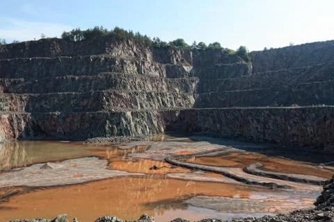 View into an open pit mine with prophyry rock material Stock Photos