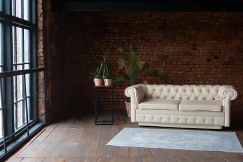 View on an open space loft interior with big windows filled with sunlight Stock Photos