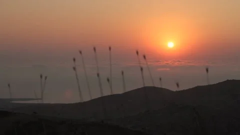 View of an orange evening sun diving in feathery veil of clouds Stock Footage 148242041