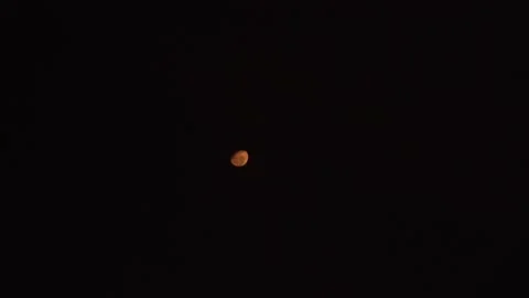 View of the orange moon in the dark night sky and blurring at the end in 4k Stock Footage 193026847