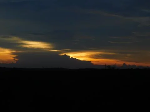 View of an orange sky between the dark clouds Stock Photos