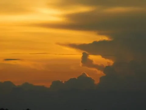 View of orange sky between dark clouds Stock Photos