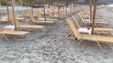 View on orange vacant sunbeds under straw sun umbrellas due to Covid-19 Stock Footage 134665088