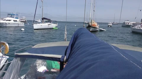 View of other moored yachts along boom of sailboat looking stern over dodger. Stock Footage 67516043