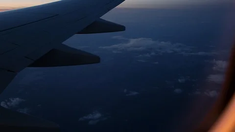 A view out of an aircraft window looking over the wing at sunset. Stock Footage 96544156