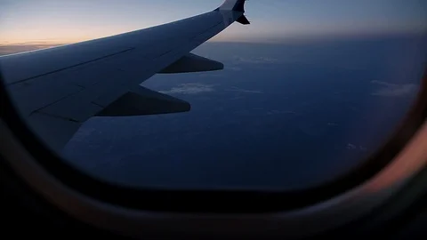 A view out of an aircraft window looking over the wing at sunset. Stock Footage 96544788