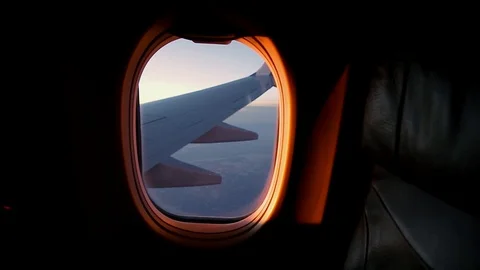 A view out of an aircraft window looking over the wing at sunset. Stock Footage 96545980