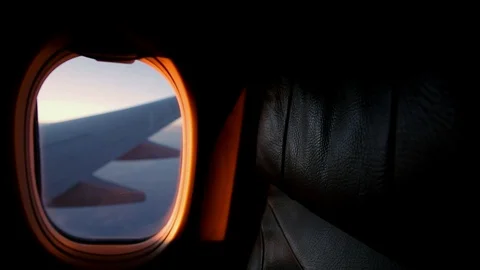 A view out of an aircraft window looking over the wing at sunset. Stock Footage 96546484
