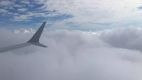 View out of airplane window plane flying down through clouds Stock Footage 184764406
