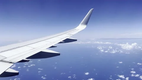 View out airplane window wing of tropical Caribbean Mexico coast blue sky clouds Видео 194173305