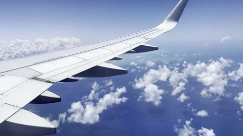 View out airplane window wing of tropical Caribbean Mexico coast blue sky clouds Видео 194173321