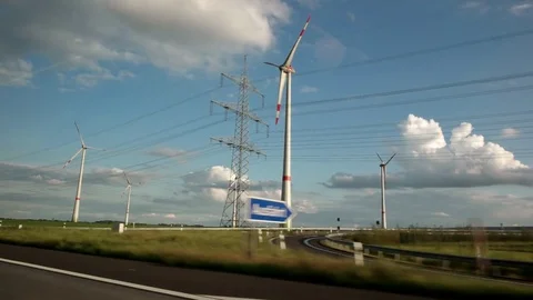 View out of car window passing by windmill farm with wind turbines. Sustainable Stock-Footage 84885915