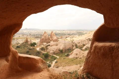 View out of a cave, window onto two fairy chimneys of the Red Valley, Rose .. Foto stock