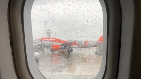 View out of a commerical plane window on a rainy day Stock Footage 112126069