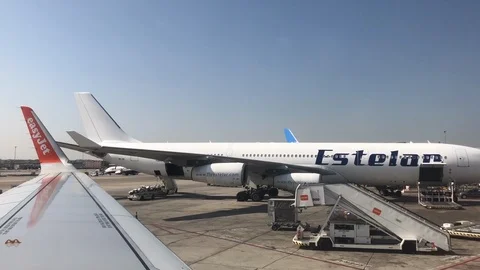 View out of commerical plane window of planes being loaded Stock Footage 112126077