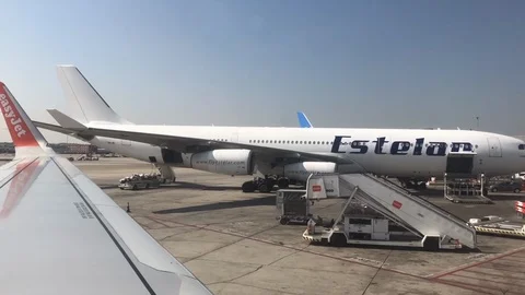 View out of commerical plane window of planes being loaded Stock Footage 112126101