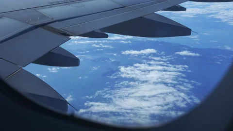 View out of flight passenger window over a sea of cloud and airplane wings Stock Footage 235929453