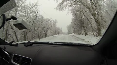 View out front windshiled while driving down snowy road Stock Footage 48375716