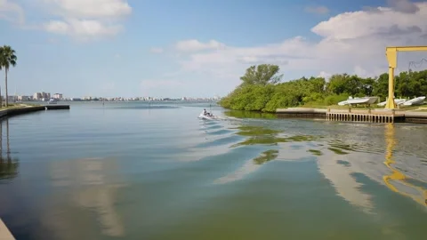 View out of Marina with reflections in water near seawall. Small boat going out Stock Footage 314994798
