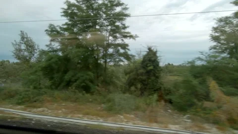 View out from moving Train window crossing small river - Italy / Nature. Stock Footage 130984095