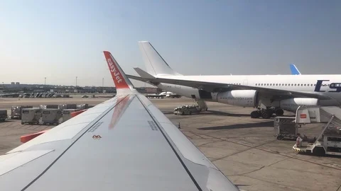 View out of plane window of planes being loaded Stock Footage 112125997
