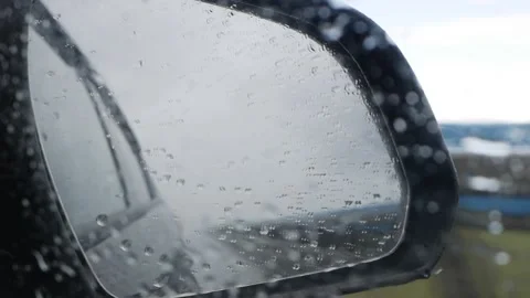 View out the rear view mirror as car drives on highway in the rain Stock Footage 137851090