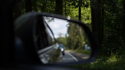View out the rearview mirror as car drives on country road. 4K Stock Footage 101787575