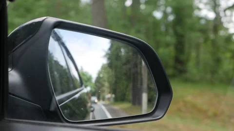 View out the rearview mirror as car drives on country road Stock Footage 137500317