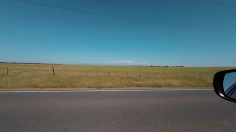 View out side window of a car at dry grass field and power lines in slow motion Stock Footage 309340216