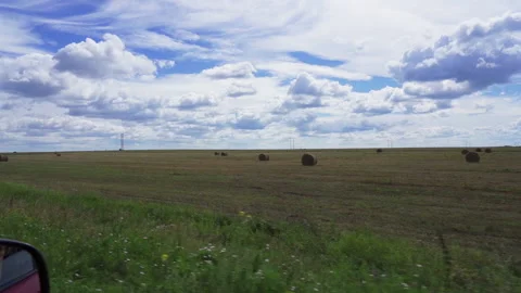 View out the side window of green fields and clouds floating across the blue sky Stock Footage 219222749
