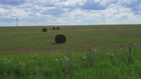View out the side window of green fields and clouds floating across the blue sky Video stock 232706124