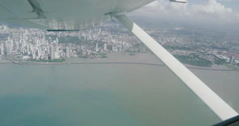 View out small plane window looking over Panama City and ocean Stock Footage 227499510