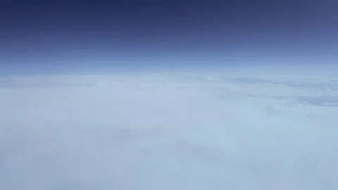 View out the window from an airplane flying high in the sky above the clouds Stock Footage 280109523