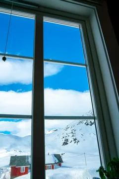 View out the window of snow capped mountains on a cold winters day. Stock Photos