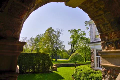 View of outdoor backyard in springtime through the arch of the building Stock Photos