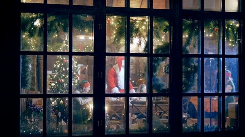View from outdoors through the big window Santa Claus, children and elves Stock Footage 111418547