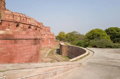 View of the outer red sandstone wall and moat of Agra Fort in Agra, India. Stock Photos