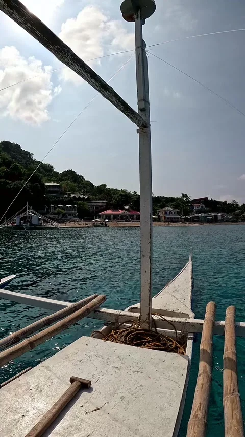 View from an outrigger boat or bangka sailing in clear blue water approaching Ap Vídeos de archivo 318637726