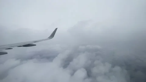 View from outside of an airplane wing slowly flying through hazy clouds Stock Footage 194430102