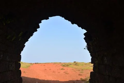 A view of the outside open area from inside a dark fort in India Foto stock