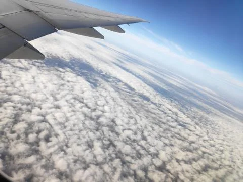 View outside plane window on wing and clouds 库存照片