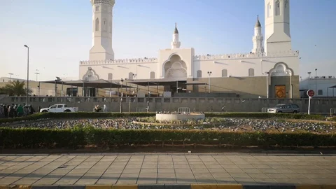 View from outside the Quba mosque with visitors and pigeons scattered Stock Footage 124909001
